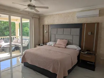 a bedroom with a large bed and a balcony at Hispanola Beach 3 Bdr Outdoor Jacuzzi in Sosúa