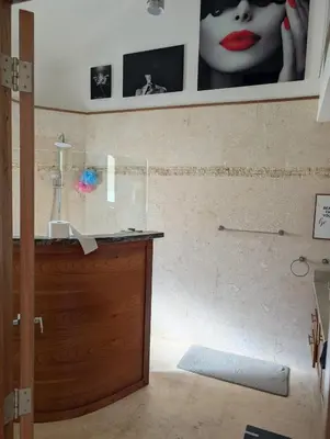 a bathroom with a sink and a wall with pictures at Hispanola Beach 3 Bdr Outdoor Jacuzzi in Sosúa