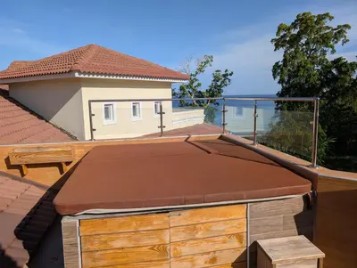 a balcony with a roof with a view of the ocean at Hispanola Beach 3 Bdr Outdoor Jacuzzi in Sosúa