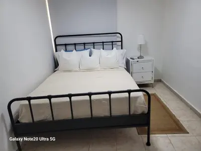 a bedroom with a bed with white sheets and pillows at Apartamento dos dormitorios en la zona colonial in Santo Domingo