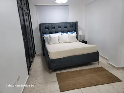 a bed with a black headboard in a bedroom at Apartamento dos dormitorios en la zona colonial in Santo Domingo