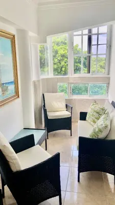 a living room with chairs and a couch and windows at A Few Steps to Malecon and Sunny Beaches in San Felipe de Puerto Plata