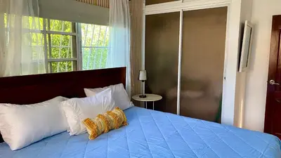 a bedroom with a blue bed with two pillows at A Few Steps to Malecon and Sunny Beaches in San Felipe de Puerto Plata