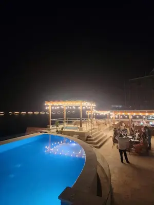 a swimming pool at night with people sitting around it at Acogedor apartamento en Samaná con vista al mar in La Aguada