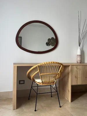 a wicker chair sitting in front of a mirror at Acogedor apartamento en Samaná con vista al mar in La Aguada