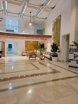 a large room with a lobby with tables and chairs at Acogedor apartamento en Samaná con vista al mar in La Aguada