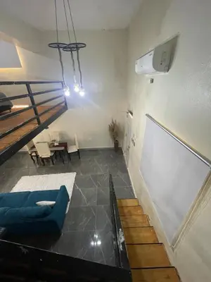 a living room with a blue couch and a table at Lofts R&L in Juan de Herrera