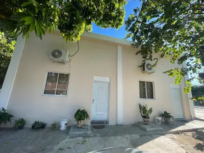 a white house with a dog sitting in front of it at Lofts R&L in Juan de Herrera