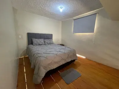 a bedroom with a bed and a flat screen tv at Lofts R&L in Juan de Herrera