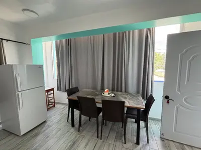 a kitchen with a table with chairs and a refrigerator at Calle Roma in Bayahibe