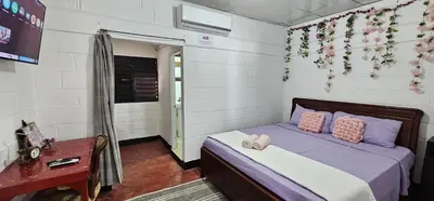 a bedroom with a bed with pink pillows at Brisas de Jarabacoa in Jarabacoa