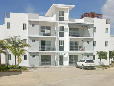 a white building with a car parked in front of it at Peaceful Cottage in Santiago de los Caballeros