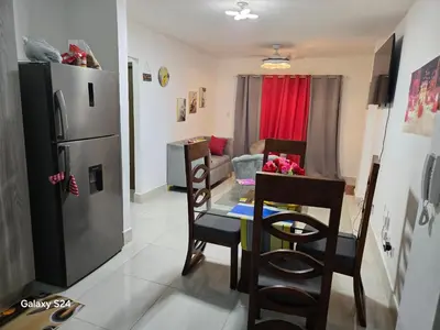 a kitchen with a refrigerator and a table and chairs at Peaceful Cottage in Santiago de los Caballeros