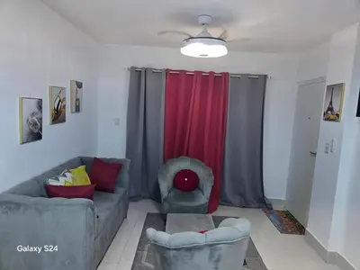 a living room with a couch and a red curtain at Peaceful Cottage in Santiago de los Caballeros