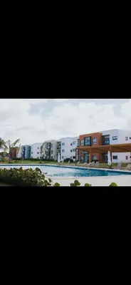a picture of a swimming pool in front of buildings at Costa bávaro garden in Punta Cana