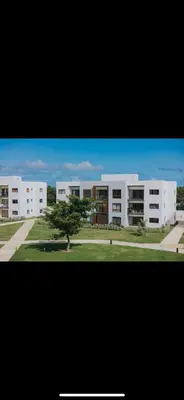 a large white building with a tree in front of it at Costa bávaro garden in Punta Cana