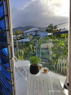 a balcony with two chairs and a table with a plant on it at Apartament with Beautiful Mountain View in Puerto Plata