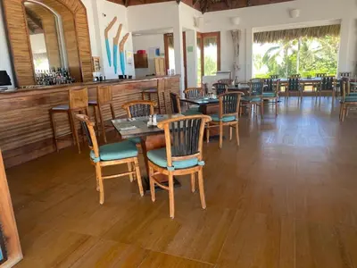 a dining room with wooden tables and chairs at Beach Golf penthouse Arena Gorda Beach P C in Punta Cana