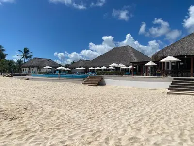 a beach with a row of umbrellas and a resort at Beach Golf penthouse Arena Gorda Beach P C in Punta Cana