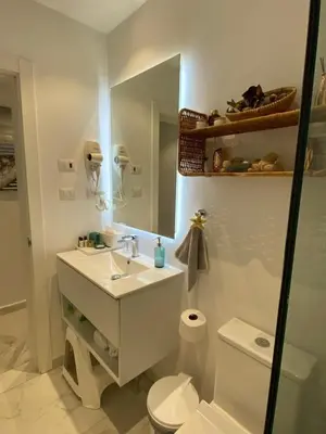a bathroom with a sink and a toilet and a mirror at Beach Golf penthouse Arena Gorda Beach P C in Punta Cana
