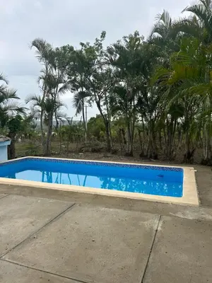 a blue swimming pool with trees in the background at Villas Maniscalco in Camú