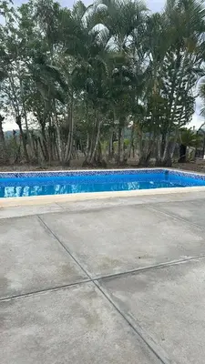 a blue swimming pool with trees in the background at Villas Maniscalco in Camú