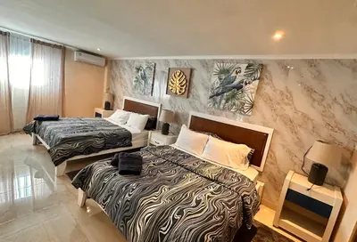 a hotel room with two beds and a wall at Noe hotel in Punta Cana