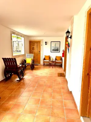 a living room with a tiled floor with rocking chairs at Noe hotel in Punta Cana