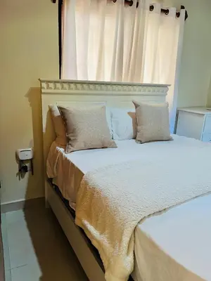 a bed with two pillows on it with a window at Brisas de Valle in Jarabacoa