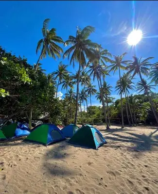 a group of tents on a beach with palm trees at Playa Rene RD in San Felipe de Puerto Plata