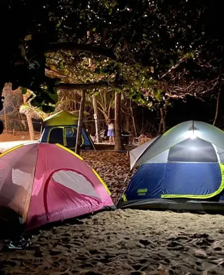 two tents sitting on the sand next to a tree at Playa Rene RD in San Felipe de Puerto Plata