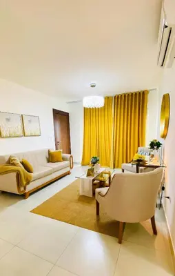 a living room with yellow curtains and a couch at Modern Rooftop Penthouse Private Large Jacuzzi for 12 in Santiago de los Caballeros