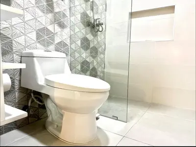a bathroom with a toilet and a glass shower at Modern Rooftop Penthouse Private Large Jacuzzi for 12 in Santiago de los Caballeros