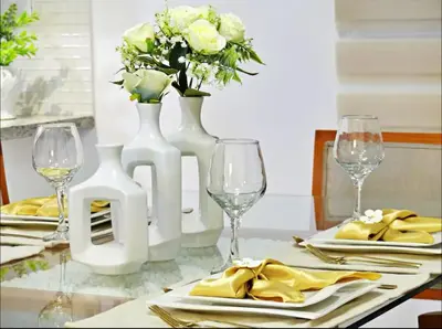 a table with two white vases with flowers on it at Modern Rooftop Penthouse Private Large Jacuzzi for 12 in Santiago de los Caballeros