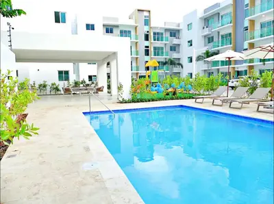 a swimming pool in front of a building at Modern Rooftop Penthouse Private Large Jacuzzi for 12 in Santiago de los Caballeros