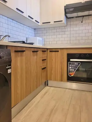 a kitchen with wooden cabinets and a stove top oven at Ona Residences Punta Cana in Punta Cana