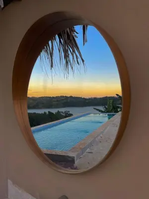a round mirror reflecting a swimming pool and a sunset at Villas del lago resort in Colorado