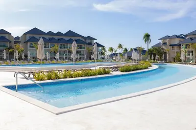 a pool at a resort with umbrellas and condos at View to paradise, One bedroom apartment in Puerto Plata