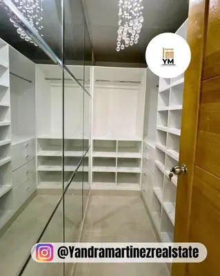 a walk in closet with white shelves and a glass door at Ideal amueblado, céntrico y acogedor in Los Paredones