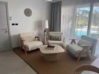a living room with chairs and a table and a clock at Estrella Izha 204 in La Laguna