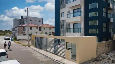 two people walking down a street next to a building at Cozy Nest in La Romana