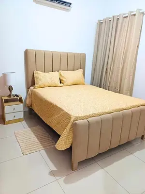 a bed with a yellow bedspread and a night stand at Luxury Beachside Escape 3BR 2BA with Pool & Ocean Views in San Felipe de Puerto Plata