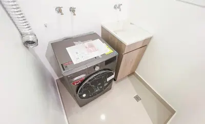 a washing machine in a bathroom next to a sink at Livera park in Santiago de los Caballeros