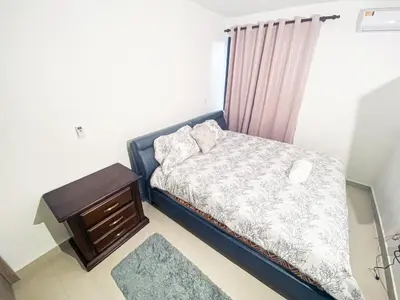 a small bedroom with a bed and a table at Livera park in Santiago de los Caballeros