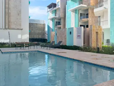a swimming pool in the middle of a building at Maple Beach Residences Punta Cana in Punta Cana