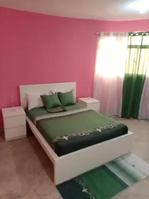 a bedroom with a bed with green and pink walls at Carvajal in El Higo