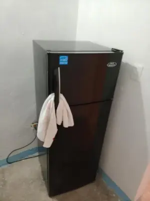 a black refrigerator with a towel hanging from it at Carvajal in El Higo