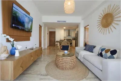 a living room with a couch and a tv at Apartamento Moderno en Playa Dorada Piscina & Playa in Puerto Plata