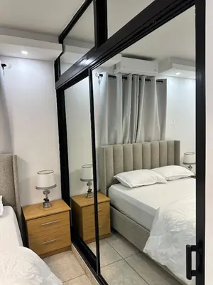 a bedroom with two beds and a mirror at Apartamento en la romana residencial los García I in La Romana