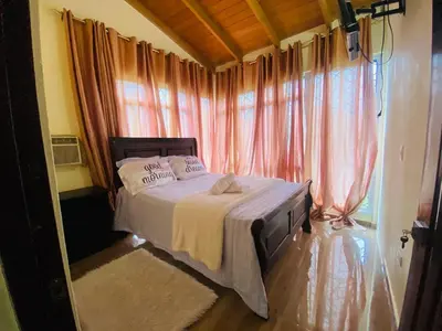 a bedroom with a bed in a room with curtains at Paris London hause in Los Grini